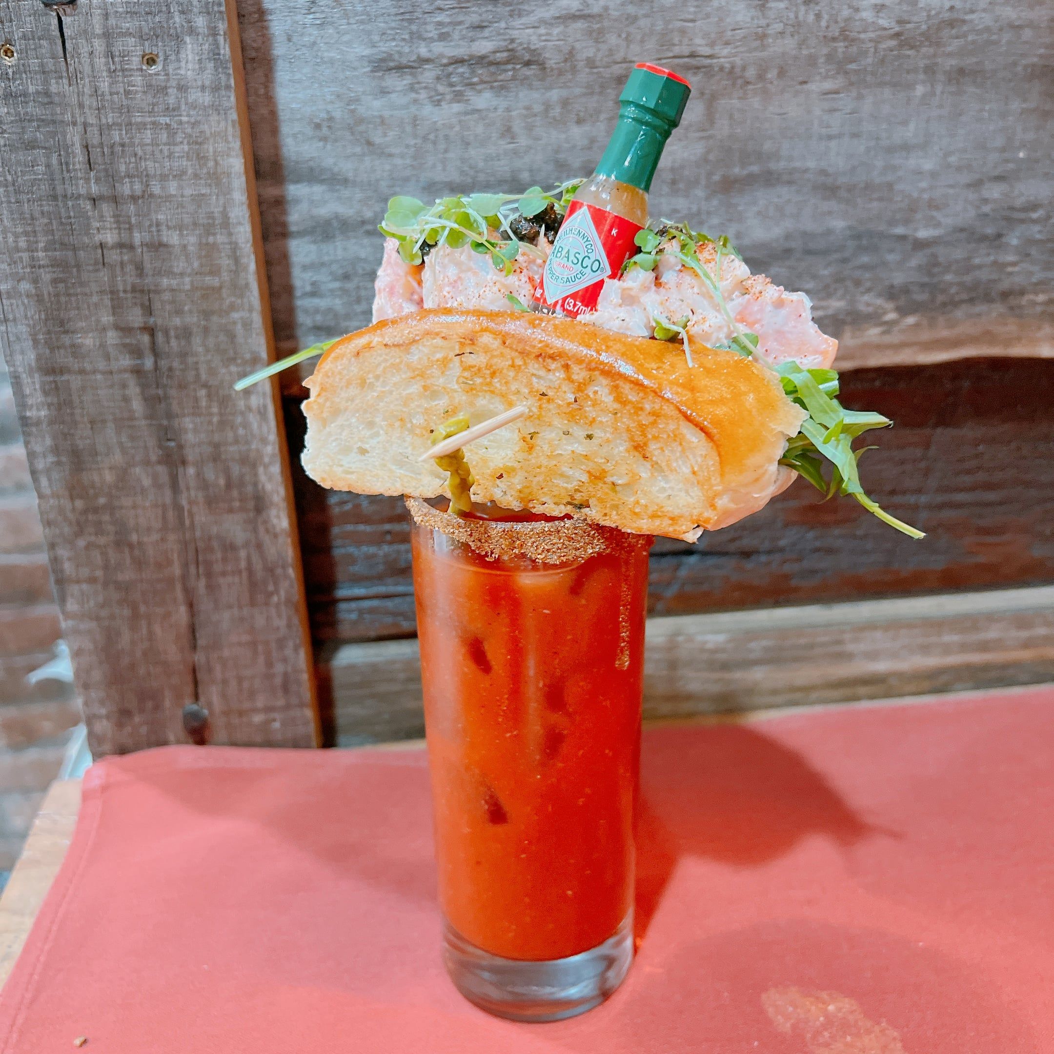 The house bloody mary, garnished with a mini lobster roll and a tiny Tabasco bottle