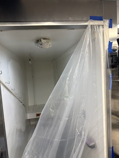 The walk-in cooler still wrapped in protective plastic during installation