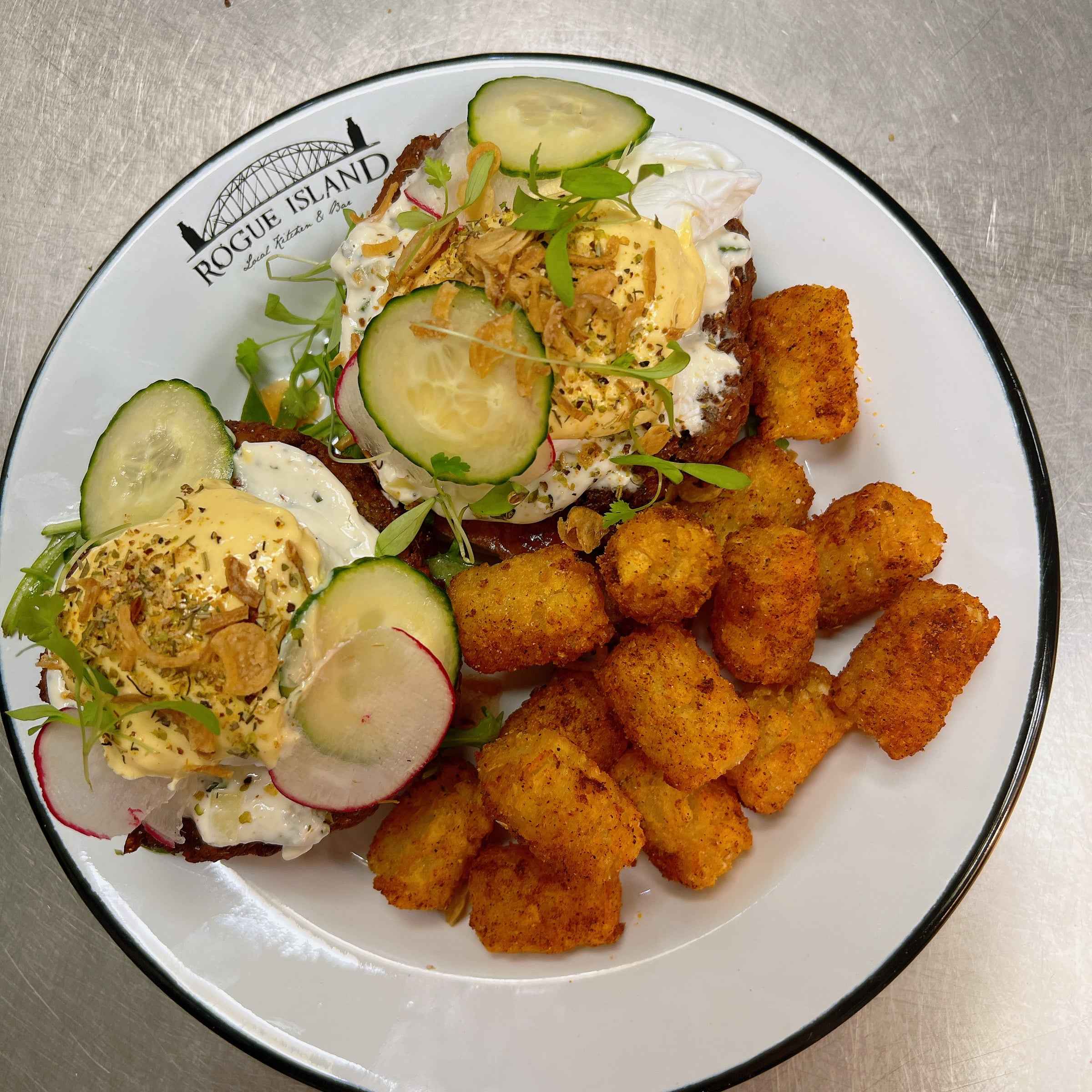 Fried chicken benedict with poached eggs and spiced tots on the Rogue Island branded plate