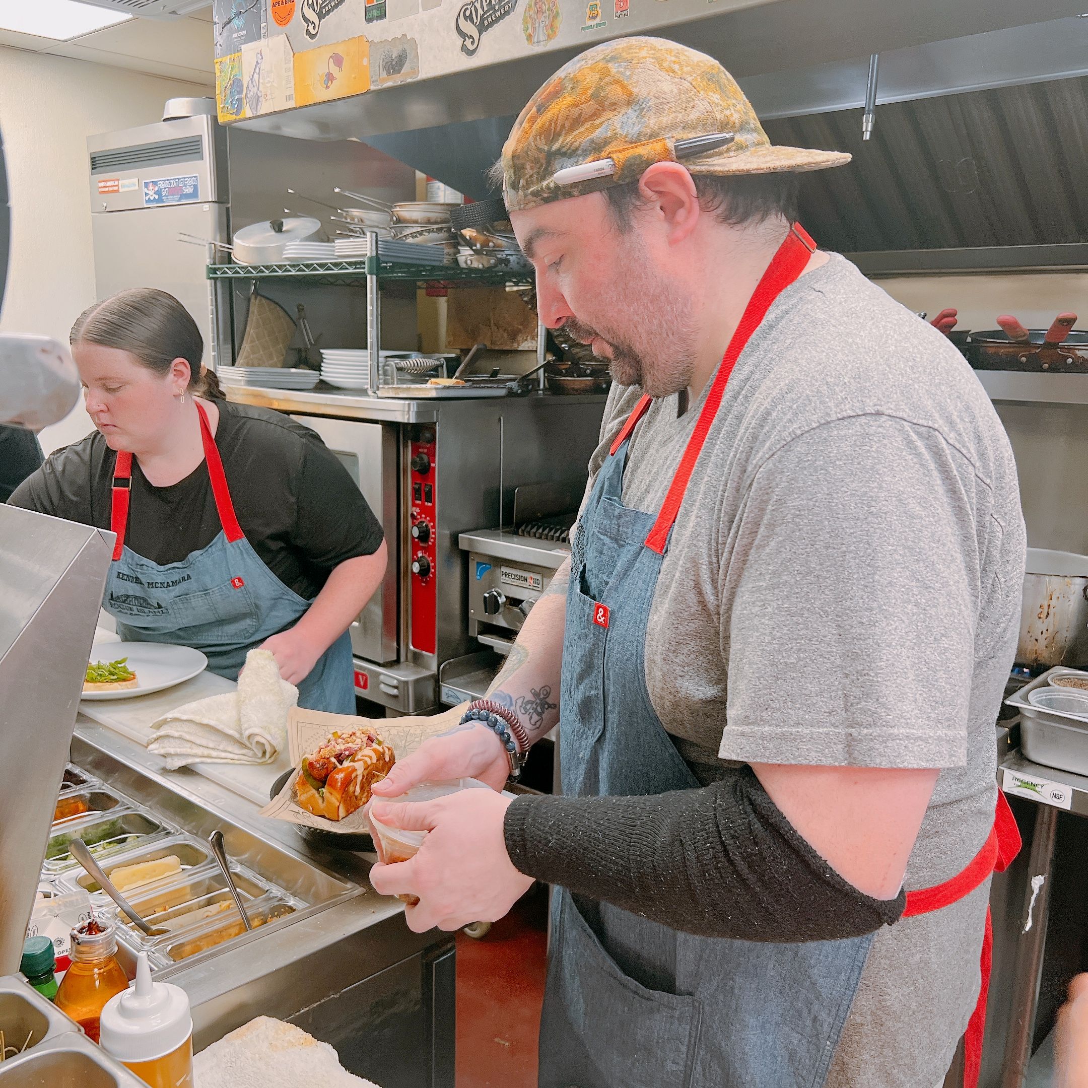 Kitchen staff plating a sandwich at Rogue Island