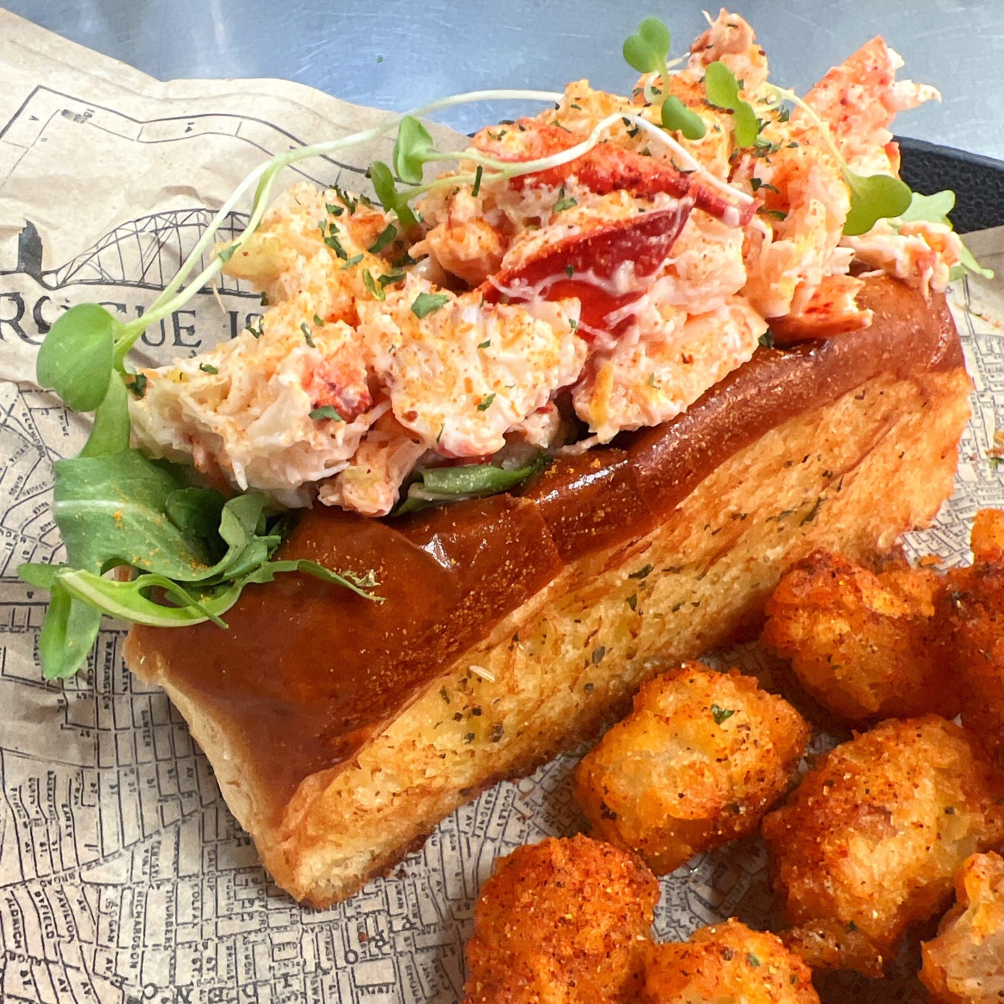 Award-winning Maine lobster roll with spiced tots