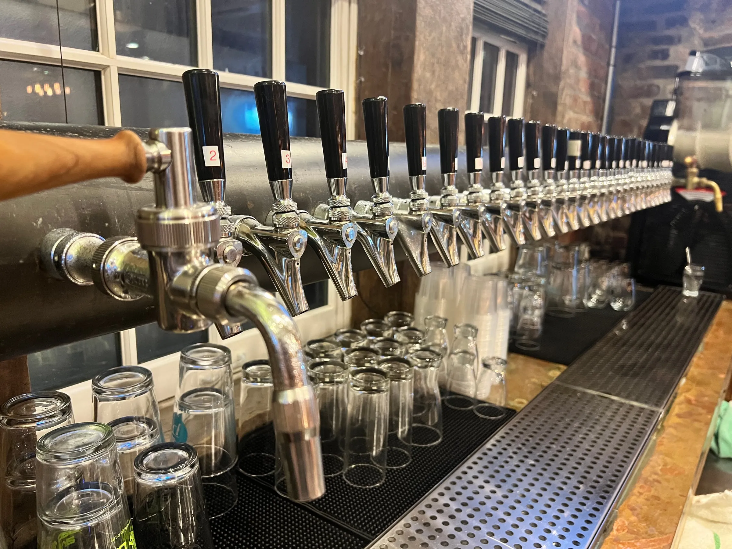 The draft rail behind the bar — a full row of rotating Southeastern New England taps